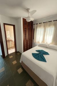 a bedroom with a bed with a blue flower on it at Pousada Mazé in Itanhaém