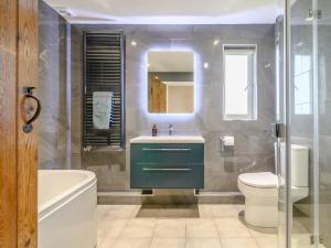 a bathroom with a sink and a toilet and a mirror at 3 Bed in Talybont-on-Usk 88139 in Talybont +46 photos