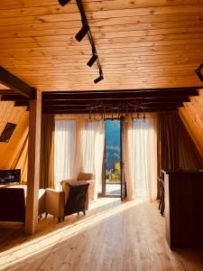 a living room with wooden ceilings and a large window at Mtis Racha in Oni