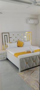 1 dormitorio con 1 cama blanca grande con detalles en oro en AQUA GARDENS SEAVIEW LUXURIOUS HOMESTAY NYALI Msa, en Mombasa 16 fotos más