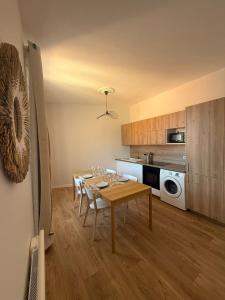 ヴェルネ・レ・バンにあるAppartement de charme et lumineux, 2 chambresのテーブルと椅子のあるキッチンとダイニングルーム