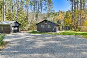 a house and a garage next to a driveway at Riverfront Cabin w/ Hot Tub in Schroon Lake! in Schroon Lake