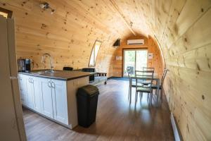 cocina y comedor de una cabaña de madera en The Hobbit tiny house dogfriendly, en Saint-Alexis-des-Monts