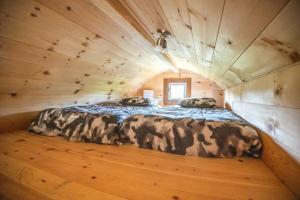 Un dormitorio en una cabaña de troncos con una cama dentro. en The Hobbit tiny house dogfriendly, en Saint-Alexis-des-Monts