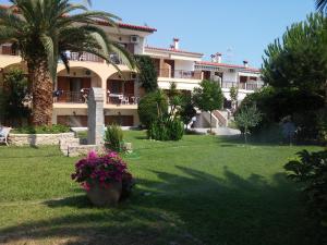 un gran edificio con palmeras y flores en un patio en Asteras hotel, en Chaniotis