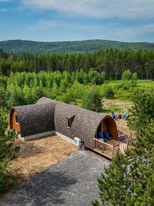 una casa con techo de paja en un campo en The Hobbit tiny house dogfriendly, en Saint-Alexis-des-Monts