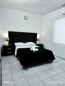 ein Schlafzimmer mit einem schwarzen Bett mit weißen Kissen in der Unterkunft sunrise in Cancun in Cancún