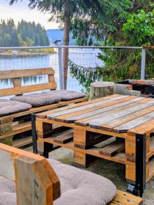 a group of wooden benches sitting next to the water at Panoramic Belis Fantanele in Beliş