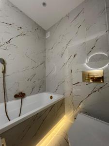 a white bathroom with a tub and a toilet at Nowe luksusowe Apartamenty MANUFAKTURA-Prywatny na wyłączność-Wanna-Zamykany ogrodzony Parking, Blok,Niskie pietro-cisza i spokój in Łódź