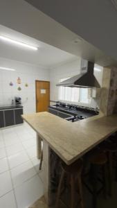 a kitchen with a counter top and a stove at Casa da Rosa in Goiânia +31 photos
