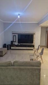 a living room with a couch and a flat screen tv at Casa da Rosa in Goiânia