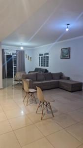 a living room with a couch and two chairs at Casa da Rosa in Goiânia