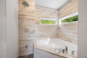 a bathroom with a tub and a window at Laurentides Scandinavian Chalet with Jacuzzi and Lake in Sainte-Lucie-de-Doncaster +31 photos
