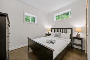 a bedroom with a bed and two windows at Laurentides Scandinavian Chalet with Jacuzzi and Lake in Sainte-Lucie-de-Doncaster