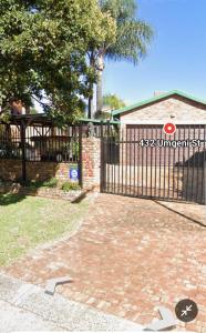 a black fence with a gate in a yard at Granny's at Umgeni in Pretoria