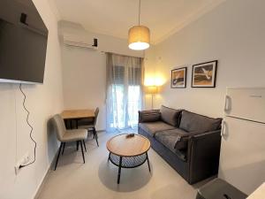 una sala de estar con un sofá y una mesa en Loutraki's Seaside Serenity, 2 BDRM apartment, en Loutraki