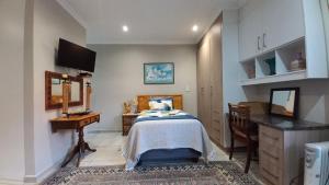 a bedroom with a bed and a table and a desk at Granny's at Umgeni in Pretoria