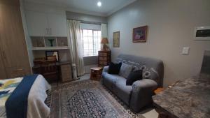 a living room with a couch and a bed at Granny's at Umgeni in Pretoria +9 photos