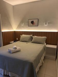 a bedroom with a bed with a towel on it at Hotel Petit Village Icaraí in Niterói