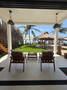 a patio with chairs and a table and a view of the beach at Eco Pousada Paraíso Casamar in São José da Coroa Grande