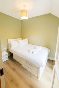 une chambre avec un grand lit avec des draps blancs dans l'établissement 2 Bedroom House Cork City Centre, à Cork
