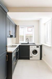 une cuisine avec un évier et une machine à laver dans l'établissement 2 Bedroom House Cork City Centre, à Cork