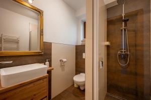 een badkamer met een wastafel, een toilet en een spiegel bij Apartmány Bobrík in Liptovský Mikuláš +41 foto's