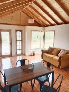 ein Wohnzimmer mit Tisch und Couch in der Unterkunft Cabaña en Playa Totoralillo in Totoralillo