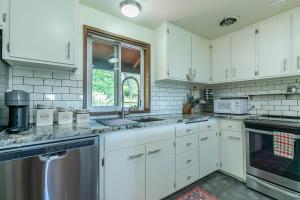a white kitchen with white cabinets and a window at 3 min to UO with amazing views! Central to all! in Eugene