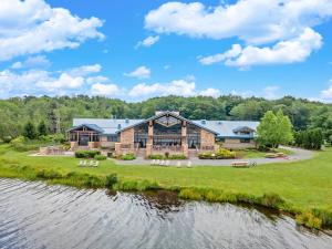 une vue aérienne d'une grande maison avec une rivière dans l'établissement Pocono Lake Escape, includes Golf Cart, Hot Tub, à Pocono Lake