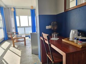 a kitchen with a wooden table and a blue wall at kasa Tambla in Ponta do Sol