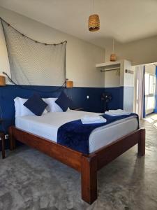 a bedroom with a large bed with blue walls at kasa Tambla in Ponta do Sol
