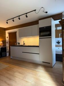 a kitchen with white cabinets and a stove top oven at Charming apartment Berggeweih Lodge at Zwölferkogel in Hinterglemm in Größing