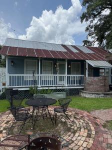 a house with a table and chairs in front of it at Courtyard by Ravens Keep in Jackson +1 photo