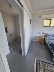 a small bedroom with a bed and a bathroom at Magna Apartment in Jeffreys Bay +7 photos