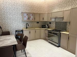 a kitchen with white cabinets and a stove at استراحة غريس الجديدة in Jeddah