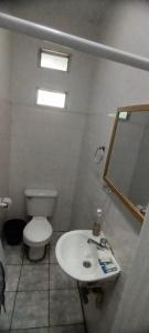 a bathroom with a toilet and a sink and a mirror at Hotel La Villa in Retalhuleu