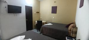 a hotel room with two beds and a television at Hotel La Villa in Retalhuleu
