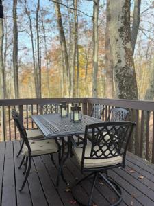 a black table and chairs on a wooden deck at Walking Distance to the Beach Cabin with AC in Arrowhead Lake