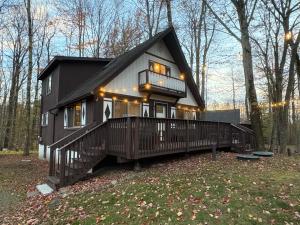 a black and white house in the woods at Walking Distance to the Beach Cabin with AC in Arrowhead Lake