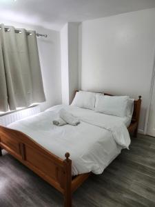 a bedroom with a bed with white sheets and a window at 5 minutes from station and 1 minute to A13 in Dagenham Dock +1 photo