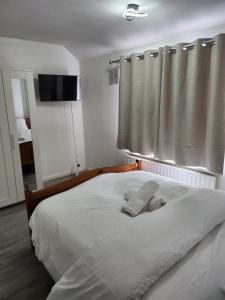 a bedroom with a large white bed with a window at 5 minutes from station and 1 minute to A13 in Dagenham Dock