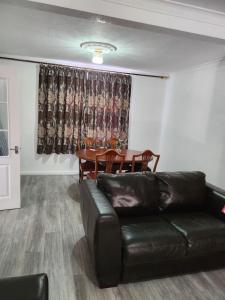 a living room with a leather couch and a table at 5 minutes from station and 1 minute to A13 in Dagenham Dock