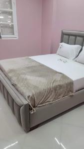 a bed in a white room with avertisementatronatronstrationstrationstration at Apartement confortable 