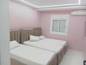 two beds in a small room with a window at Apartement confortable 