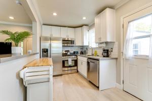 een keuken met witte kasten en een roestvrijstalen koelkast bij Charming Retreat 1 Mi to UC Davis Medical Center in Oak Park