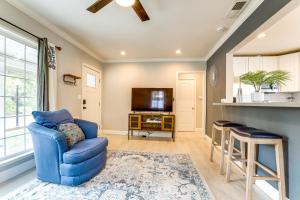 een woonkamer met een blauwe stoel en een tv bij Charming Retreat 1 Mi to UC Davis Medical Center in Oak Park
