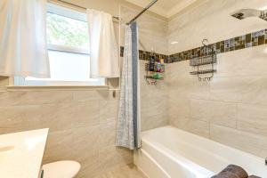 een badkamer met een wit bad en een douche bij Charming Retreat 1 Mi to UC Davis Medical Center in Oak Park +18 foto's