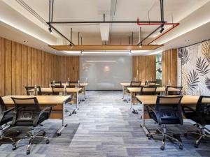 a conference room with tables and chairs and a projection screen at Tribe Bali Kuta Beach in Kuta +82 photos