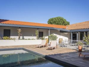 a house with a swimming pool and chairs next to a house at ibis Styles Montauban in Montauban